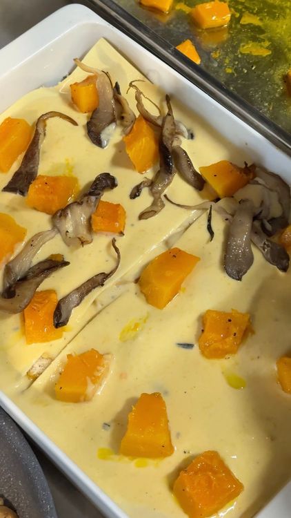 montage d'un étage de lasagne avec de la pâte fraîche, de la béchamel, des cubes de courges et des champignons
