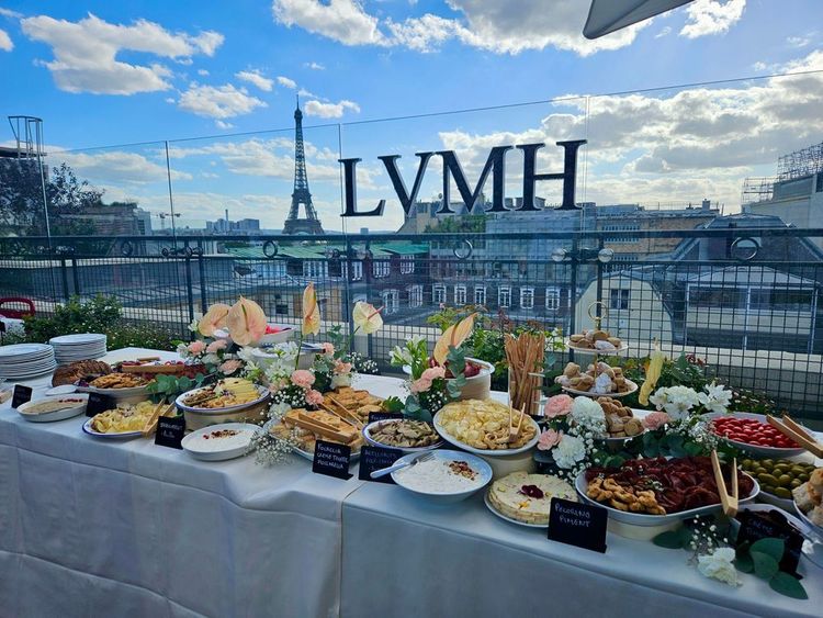 Buffet apéritif dressé avec composition florale élégante pour un événement LVMH