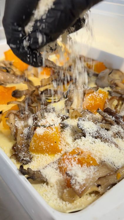 saupoudrage de parmesan sur la dernière couche de la lasagne végétarienne pour gratiner l'étage supérieur