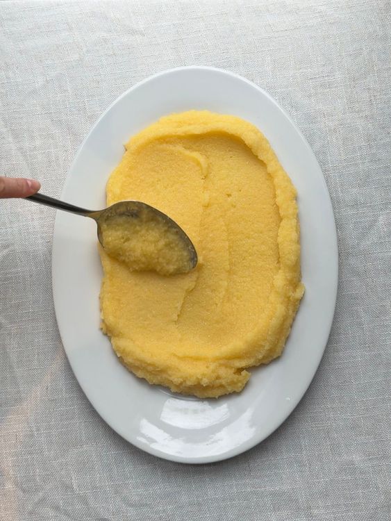 dressage dans une grande assiette blanche de polenta crémeuse