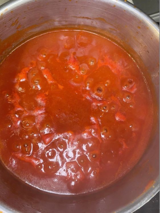 sauce tomate en train de mijoter dans une casserole en inox